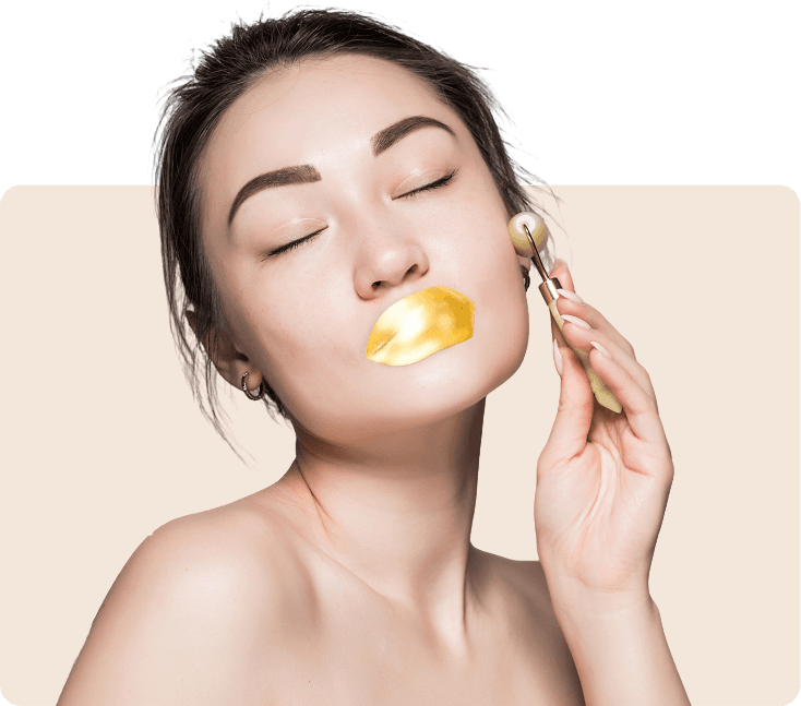 Model applying a gold lip mask