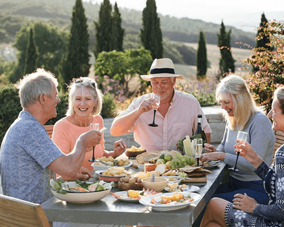 Friends sharing a meal outdoors in a sunny landscape